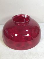 Front view of the ruby red glass hanging oil lamp shade showing rounded shape and glossy finish.