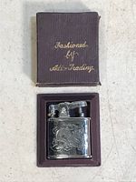 Photo showing vintage metal lighter with dragon engraving inside original box with gold lettering.
