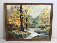 Framed oil/acrylic painting of a fall landscape with river and trees, showing entire artwork and framing.