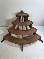 Front view of quarter-round stand showing all four curved shelves and decorative side panels.