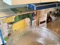 Close-up showing clear large plastic serving bowl and boxes in background