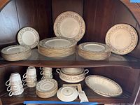Full view of Noritake Sakura china collection arranged on shelving showing plates, cups, saucers, tureen, and serving platters.