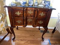 Front view of block front lowboy showing two dovetail drawers, brass bail handles and cabriole legs.