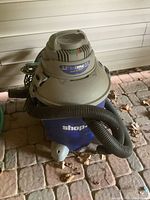 Front view of Craftsman Shop-Vac with hose coiled around it sitting on floor