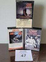 Front view of the three Ozzy Osbourne audio cassette cases displaying album covers Blizzard of Ozz, Bark at the Moon, and No Rest for the Wicked.