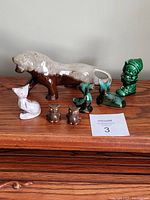 Full set of seven Blue Mountain pottery figures on a wooden surface, showing all pieces together