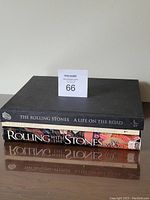 Stack of four hardcover Rolling Stones books showing spines with titles and authors.