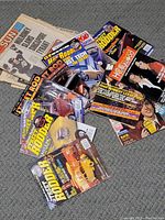 Photo showing a pile of Hot Rodder magazines, Hollywood, and other automobile and culture magazines; covers feature classic cars and celebrity photographs.
