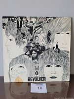 Front cover of The Beatles Revolver album with illustrated artwork collage of band members.