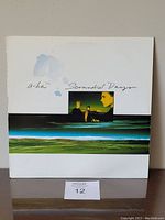 Front cover of A-ha Scoundrel Days vinyl LP showing artwork with landscape stripe and band photo under title text.