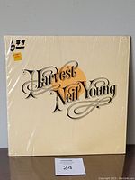 Front cover of Neil Young Harvest album in shrink wrap with cream background and stylized 'Harvest Neil Young' text
