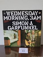 Front cover of Simon & Garfunkel Wednesday Morning, 3 AM vinyl LP album showing artist name, album title, and photo.