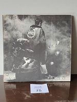Front cover of The Who Quadrophenia album gatefold showing a man with a WHO jacket standing near a scooter in a smoky scene.
