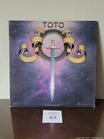 Front cover of the vinyl LP showing artwork with sword and ribbon, starry space background.