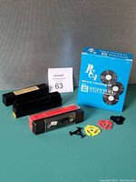 Overview of all items in lot including the Stanton RC-4 cleaning kit box, handheld cleaner, additional cleaning liquids, and 45 RPM adapters.