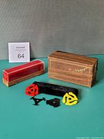Photo showing the wooden Discwasher case, microfiber cleaner, D4 liquid bottle, and multiple 45 RPM record adapters