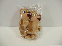 Photo showing both Chip and Dale stuffed dolls packaged together in a clear plastic bag.