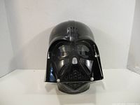 Front view of black Darth Vader mask showing helmet and face details.