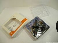 Open box showing model plane and attachments secured in clear plastic tray along with packaging and instruction sheet.