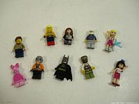 Top-down view of all 10 assorted LEGO minifigures spread out on a white surface.