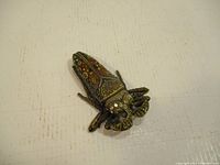 Top view of the metal insect-shaped trinket box showing detailed enamel and filigree work