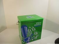 Side view of a green metal Steam Whistle cooler with logo and branding.