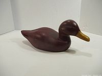 Side view of the wooden duck decoy showing full body and bill shape.