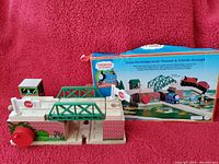 Photo of Thomas the Train lifting bridge playset with two ascending tracks, stop sign, small green signal booth, red wheels, and original box showing product details.