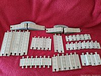 Photo showing various white plastic Thomas the Train track pieces and two small bridges with arch designs.