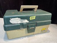 Closed green and beige Plano brand plastic fishing tackle box with handle and metal latch