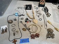 Top view of assorted costume jewellery including necklaces, rings, brooches, pendants, and earrings spread out on a flat surface.