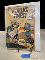 Photo of the vintage World's Finest Comics #1 comic book featuring Batman and Superman on the cover with visible age wear.