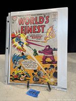 Photo of World's Finest #2 vintage comic book cover featuring a colorful action scene with Superman, Batman, Green Arrow, and a purple armored opponent.
