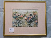Framed gouache painting by Alex Ong showing abstract pink and blue flowers, with pink mat and gold frame.