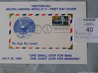 Front view showing the mounted envelope with Apollo 11 eagle illustration, postage stamp, double cancellation postmarks, and commemorative text on a white background card.