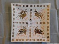 Top-down photo showing the square glass bowl with the dove of peace motifs in four quadrants and decorative geometric border.