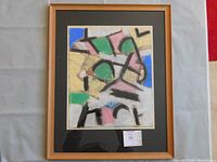 Frontal view of framed abstract painting with pastel shapes and black strokes