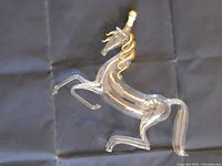 Full view of the glass unicorn bottle rearing on hind legs with gold accented mane and original stopper in place.