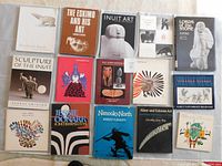 Photo showing 15 assorted books on Inuit sculpture, Eskimo art, and First Nations culture including Northern Rock, Lords of the Stone, Jessie Oonark retrospective, and others.