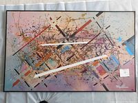 Full view of the framed abstract painting showing multicolor geometric and splatter design.