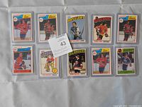 Set of 10 hockey cards in plastic sleeves laid out on a plain surface featuring Larry Robinson, Bob Gainey, Bryan Trottier, Ken Dryden, Steve Williams, Bobby Orr, and Jacques Richard.