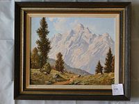Framed oil painting showing the entire artwork with alpine mountain scenery, pine trees, and dirt path.