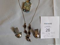 Necklace and earrings displayed flat on fabric background with seller note indicating sterling 925 with gemstones