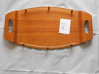 Top view of the teak serving tray showing smooth wood grain and brass railing detail.