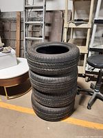 Four Michelin tires stacked vertically in a storage area, showing the sidewall and overall condition.