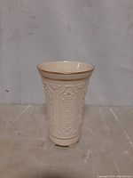 Front view of the cream-colored Lenox vase, showcasing the embossed floral and ornamental design and gold rim