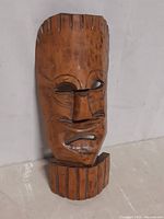 Front view of mid-century carved wooden Polynesian mask showing facial features and carved accents