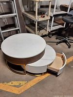 Angled view of both tables nested together, showing top surfaces and small table partially extended