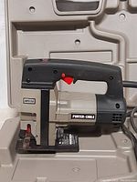 Close-up of Porter Cable jigsaw showing brand logo, trigger, blade area and power cord detail