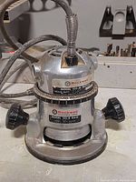 Front view of Rockwell router with visible model number plates and power cord coiled on top.